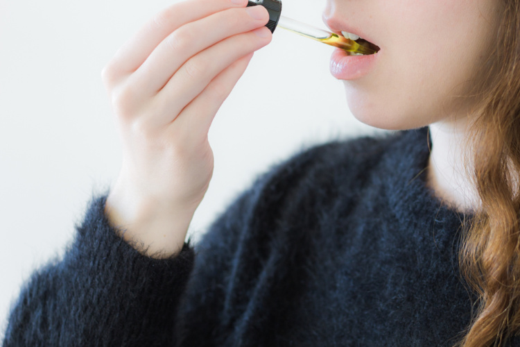 Cannabis Tinctures woman taking dropper